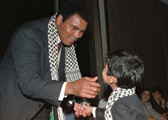 Mohamed Ali wearing a Palestinian scarf meets with Palestinian refugees  living in Iraq. Phot. Norbert Schiller
